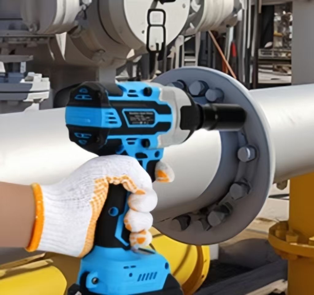A man is using an impact wrench to tighten the nut of a difficult thick pipe.