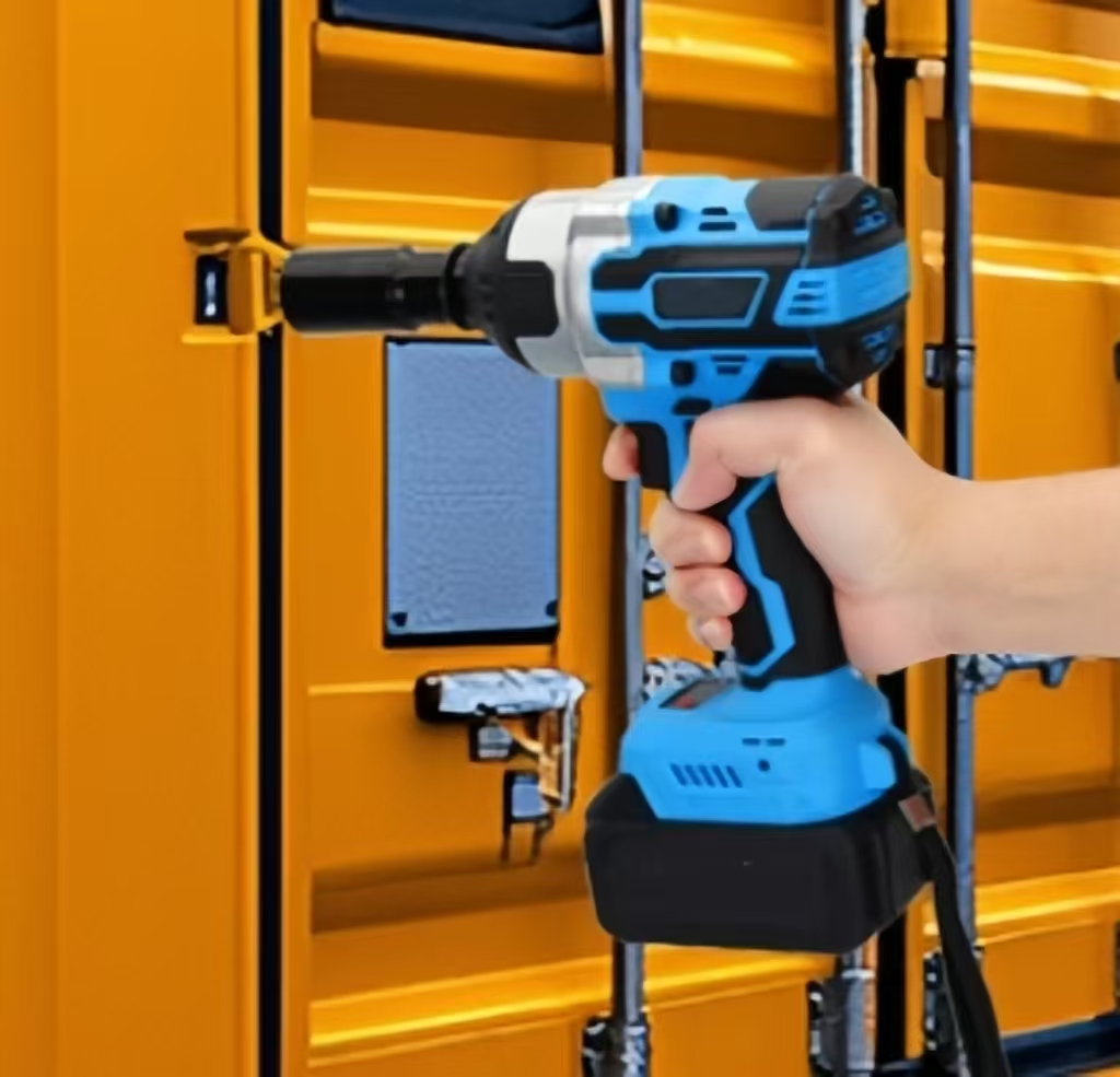 A man is tightening the nuts of a container with an impact wrench