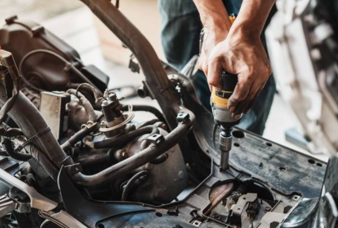 A mechanic working with an electric wrench