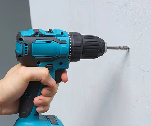 Electric drill is drilling a hole in the wall