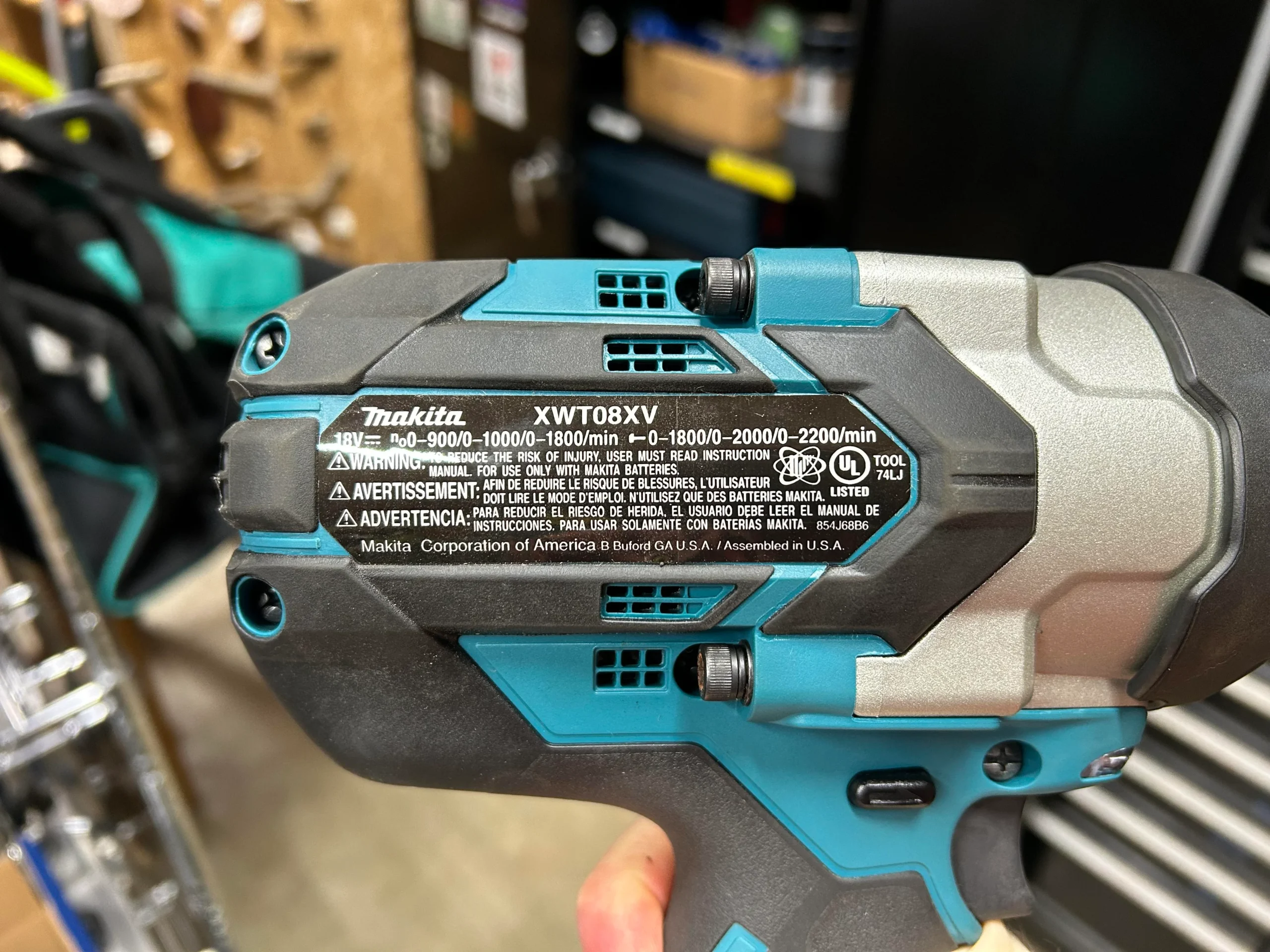 technician inspecting makita impact wrench label for manufacturing origin