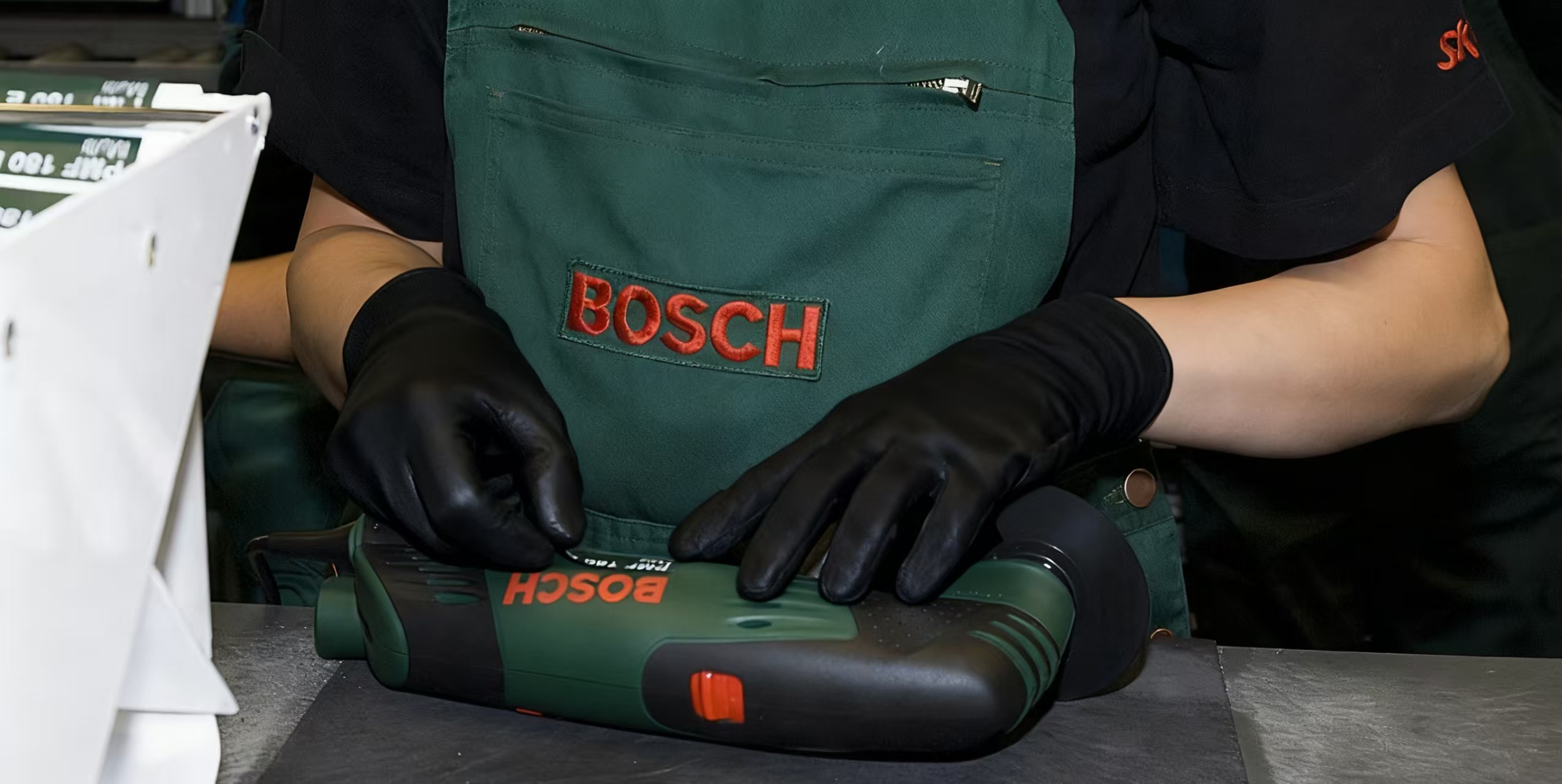 factory worker assembling bosch power tool while checking build quality on the line